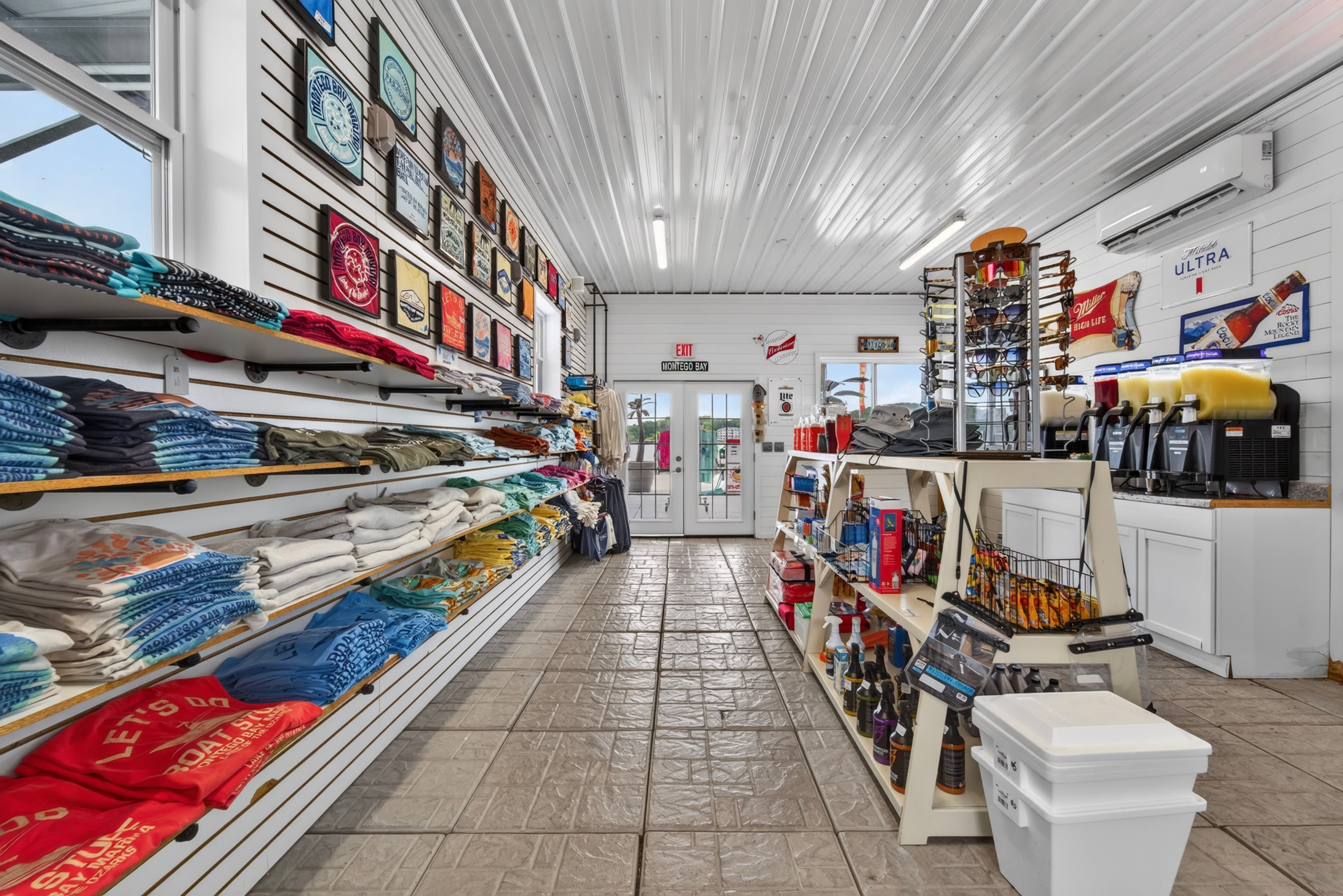Interior of a retail store showcasing shelves of clothing, merchandise, and drinks.