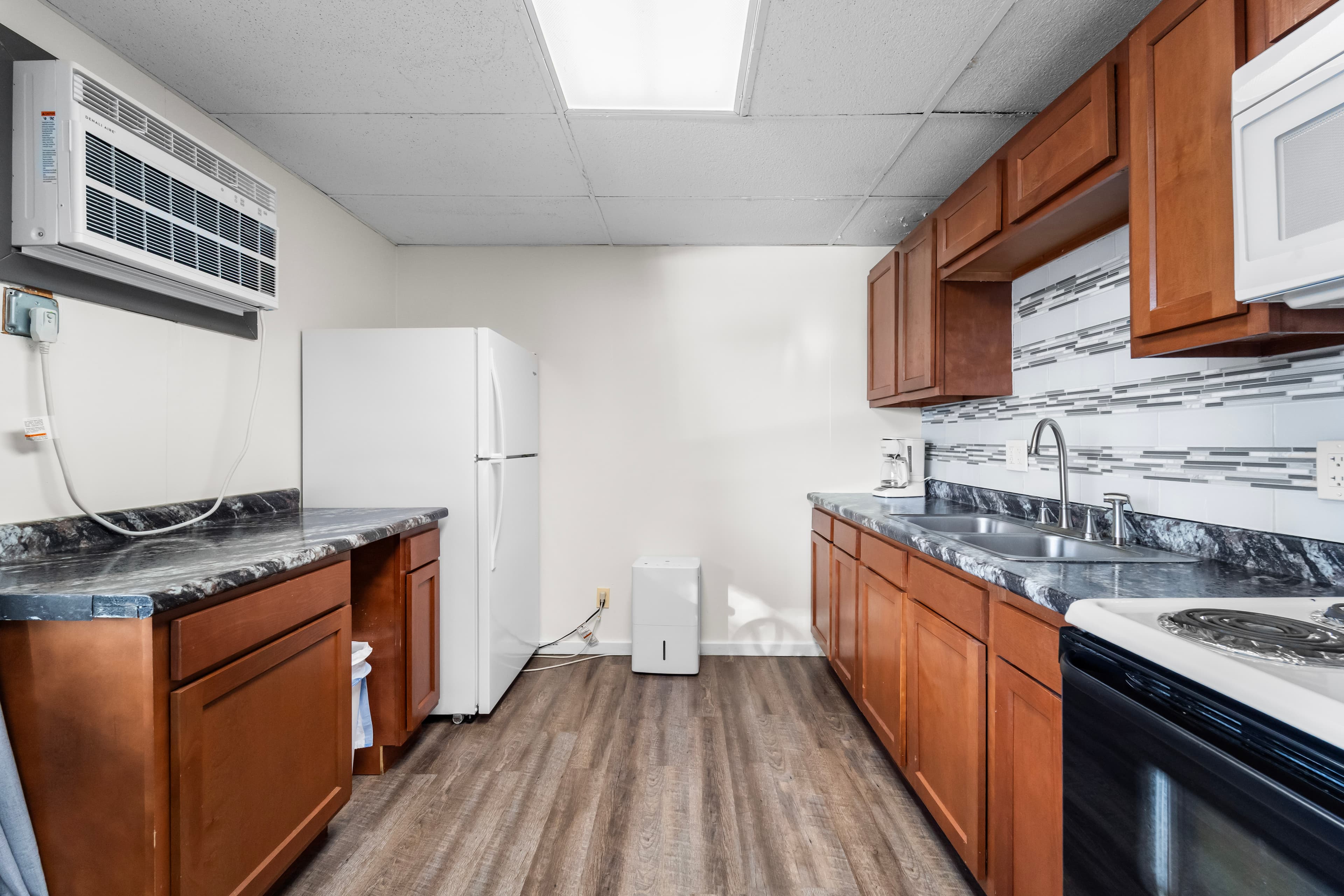 Bright kitchen featuring wooden cabinets, a white refrigerator, and modern appliances.