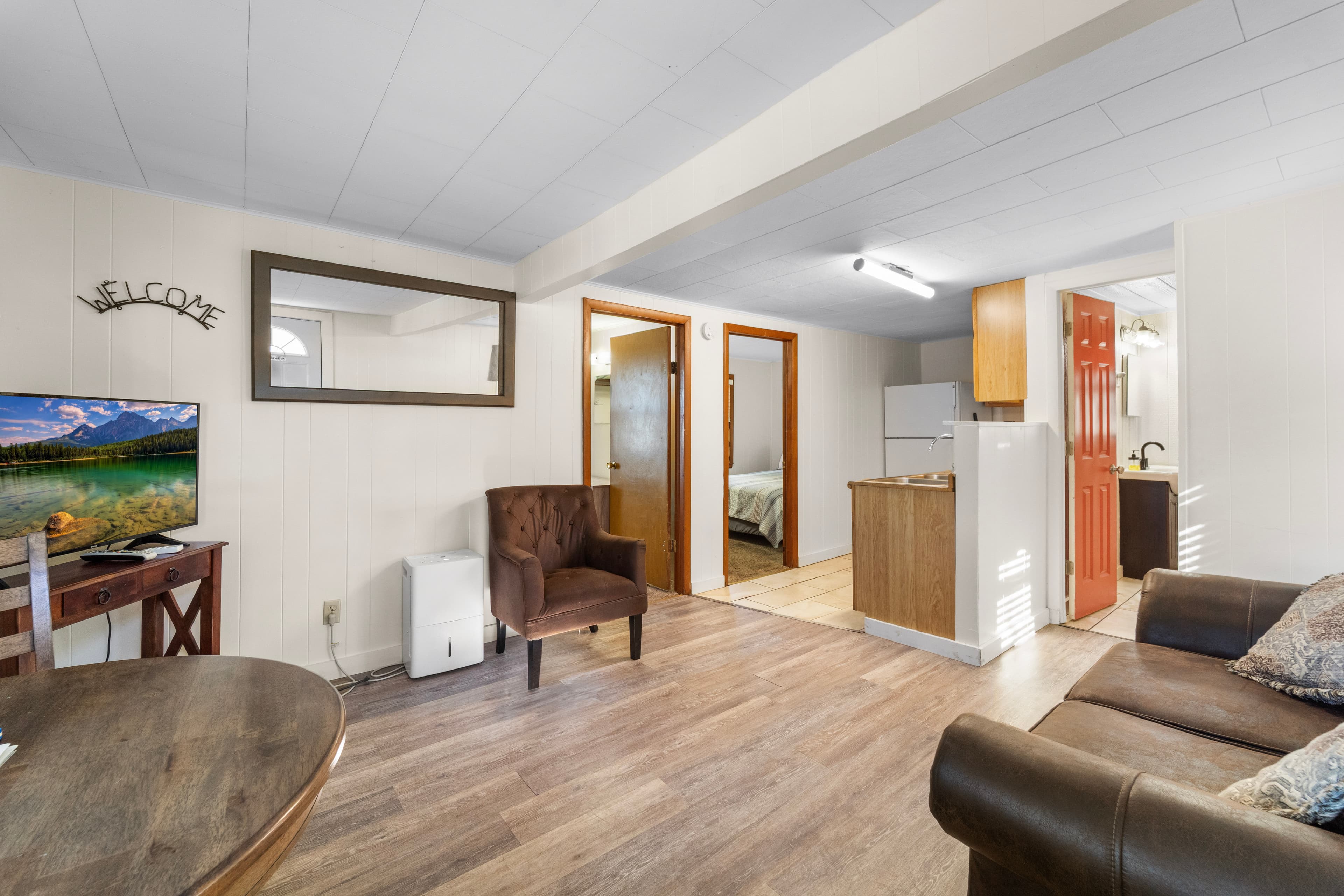 Cozy interior of a vacation rental featuring a living area, dining table, and kitchenette.