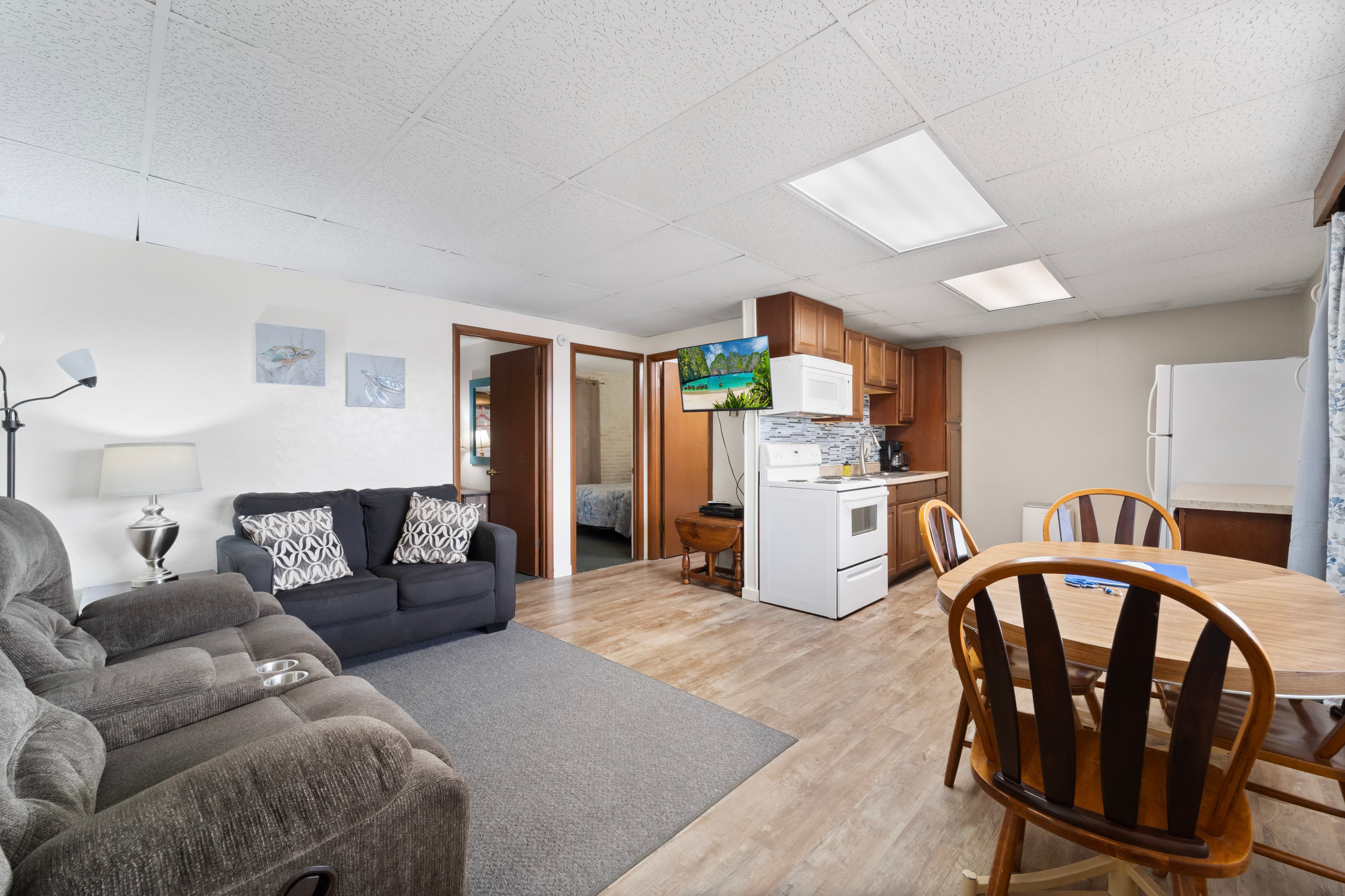 A cozy open-concept living area with a sofa, dining table, and kitchen appliances.
