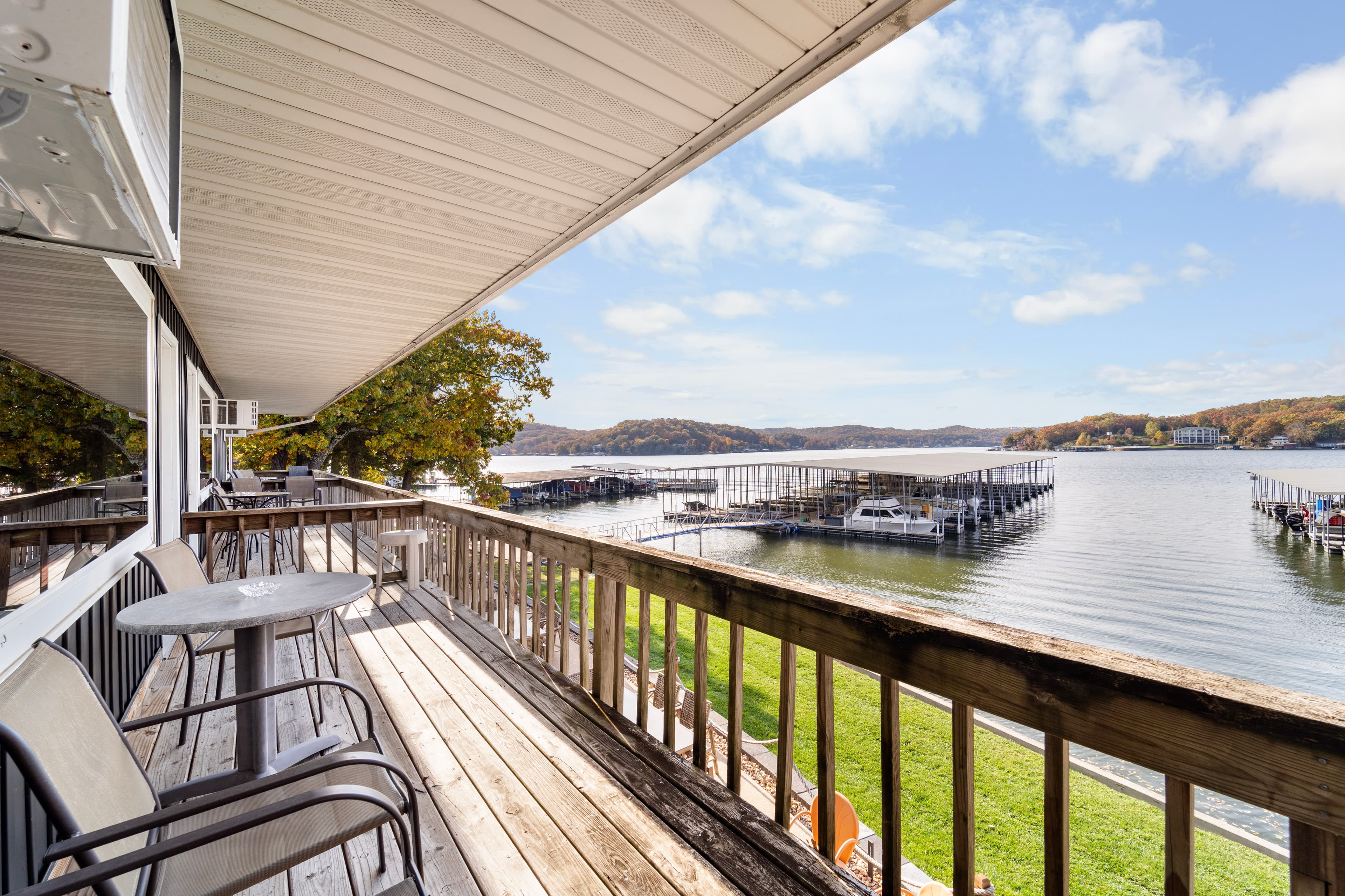 A balcony overlooking a lake with boat docks and a clear blue sky.