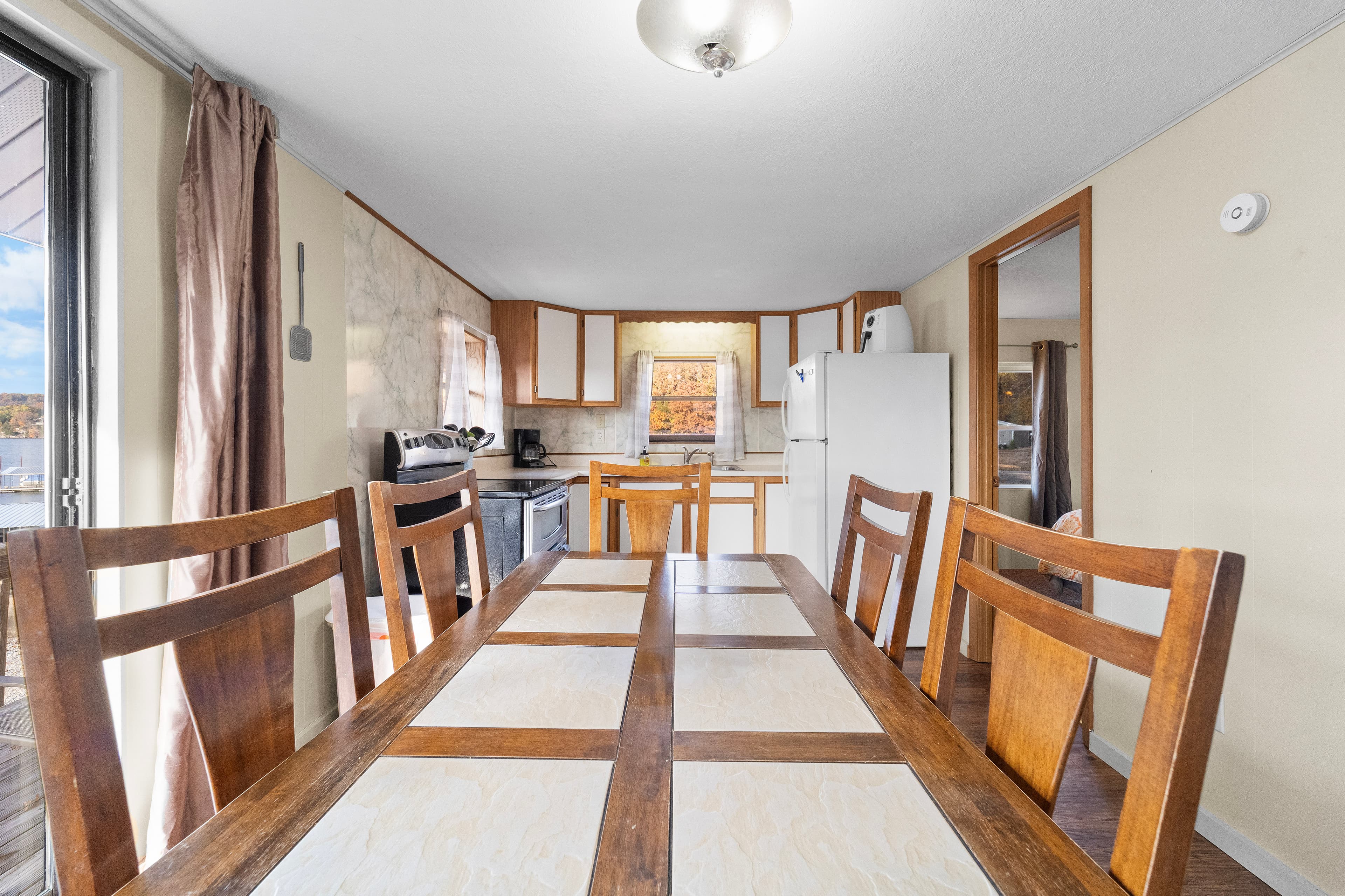 A spacious kitchen with wooden dining chairs and a view of appliances and countertops.