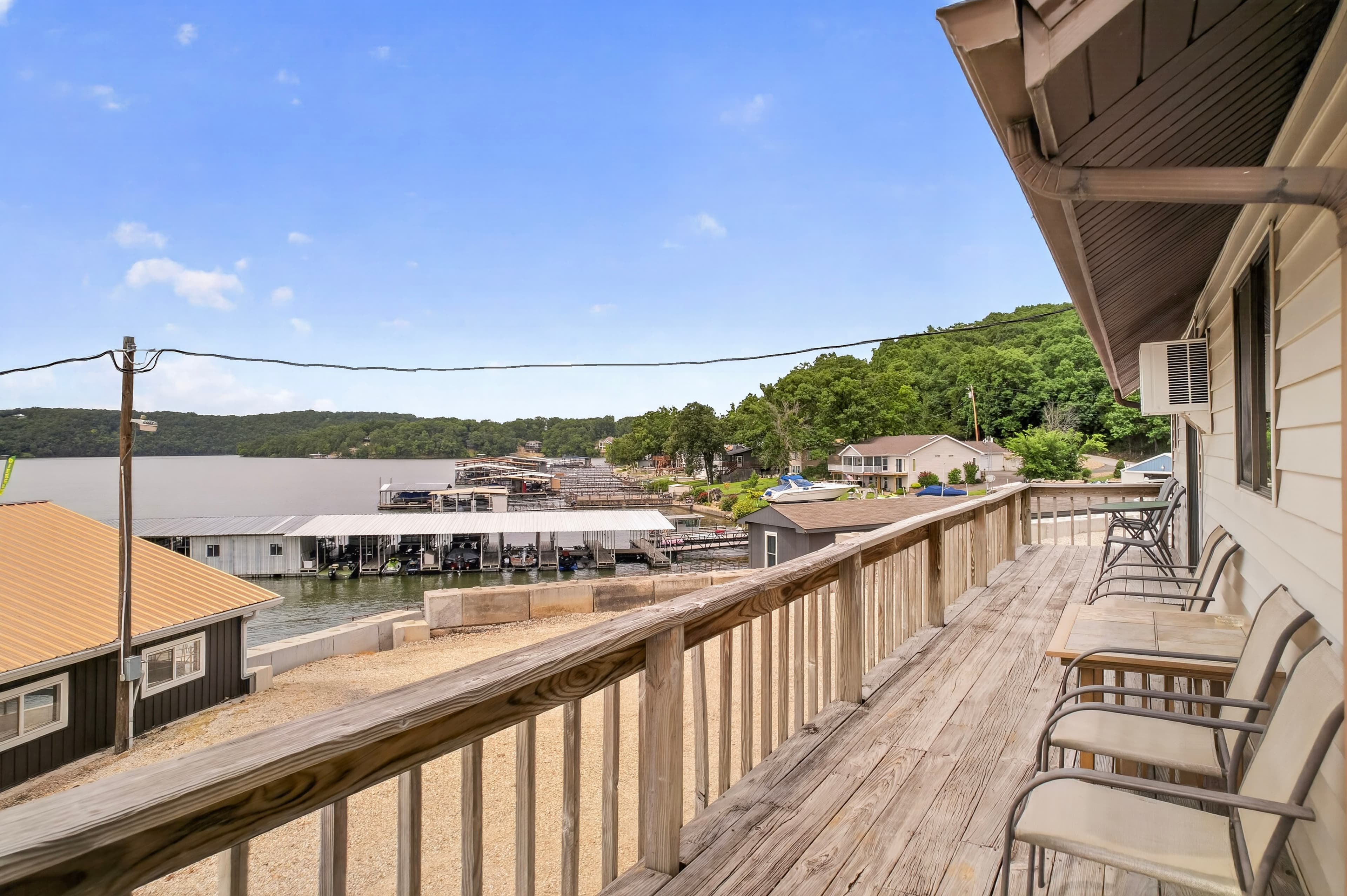 View from a wooden deck overlooking a lake with docks and nearby houses.