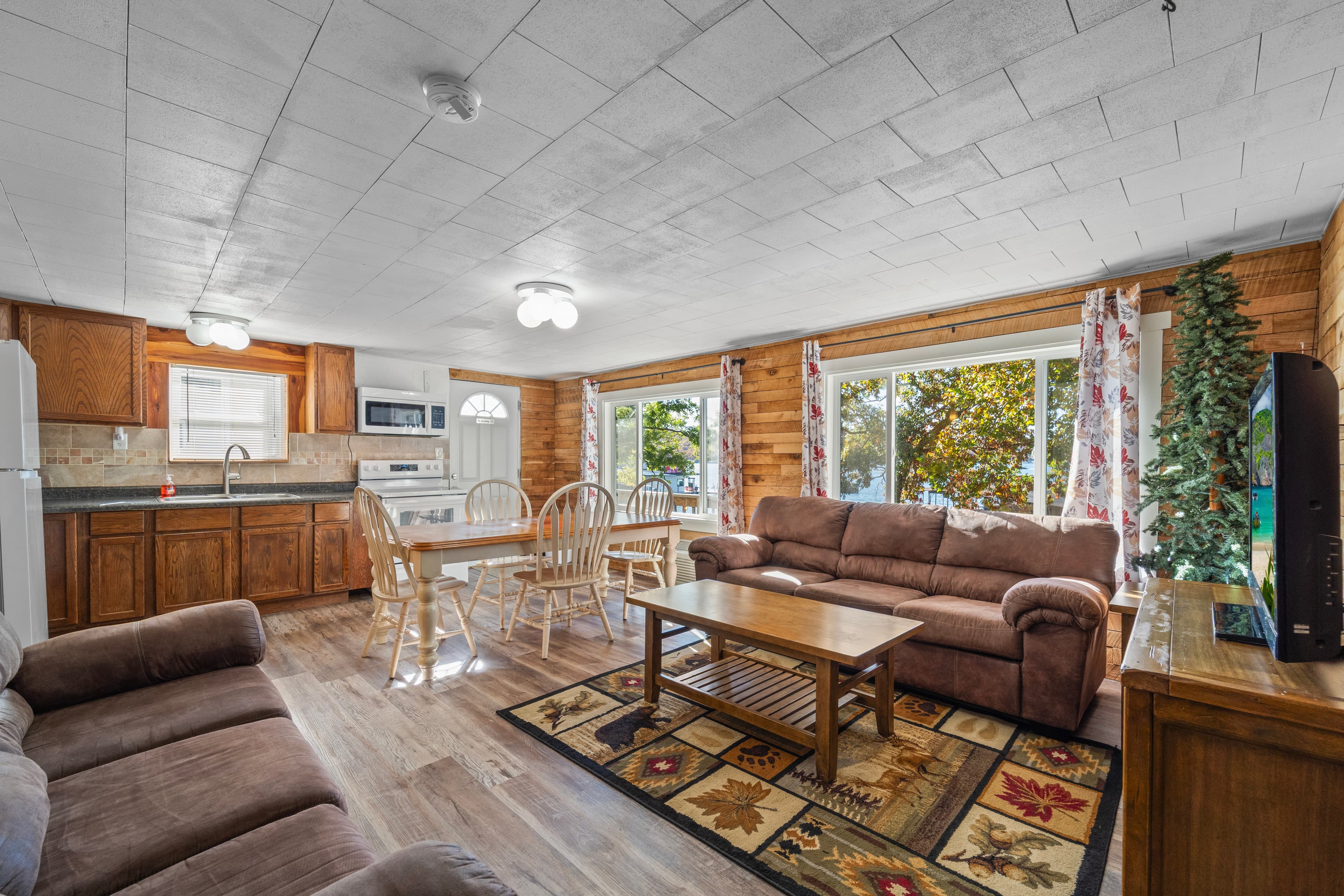Cozy living space with a kitchen, dining area, and comfortable seating near large windows.