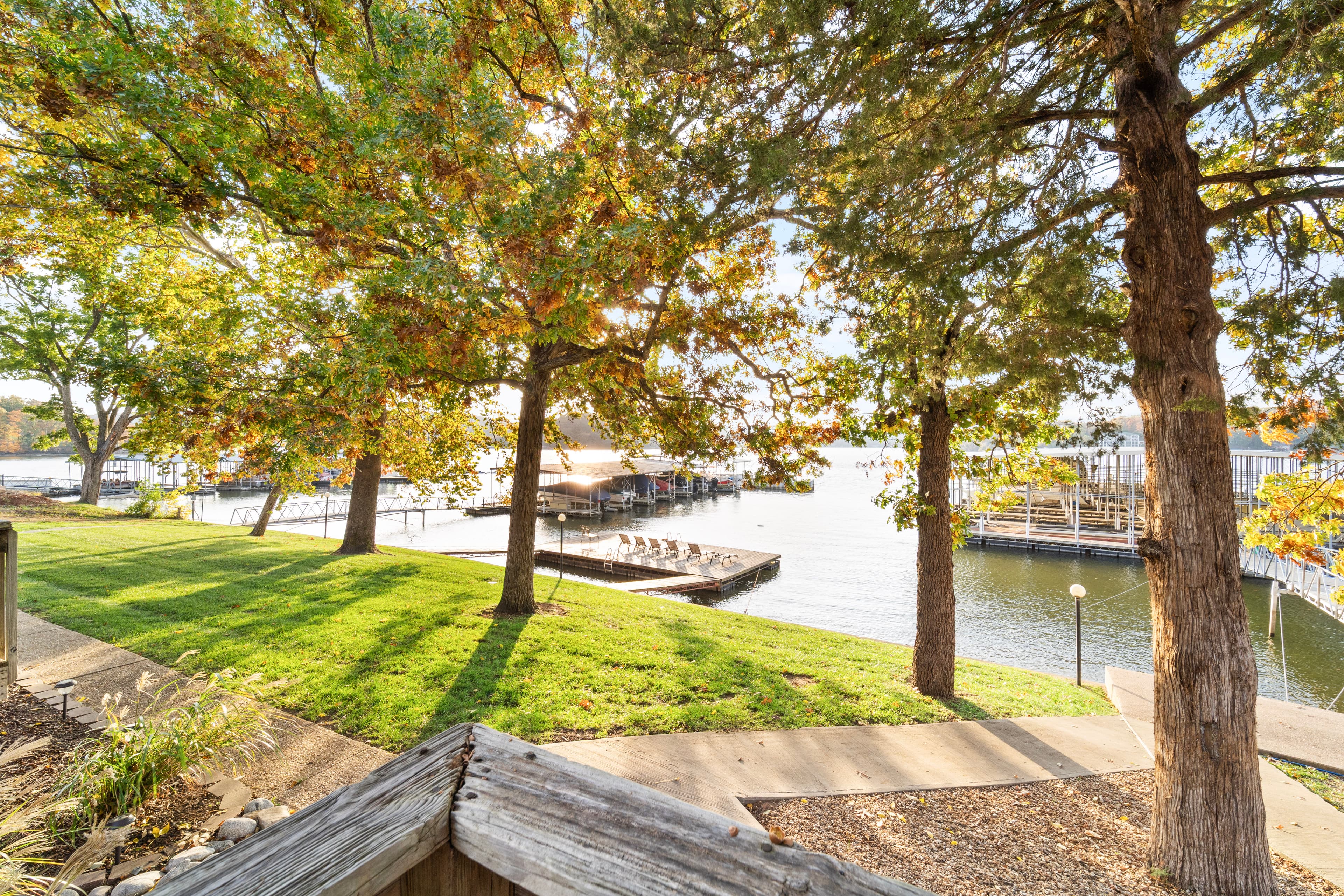 Scenic view of a grassy area near a calm waterway, framed by trees and docks.